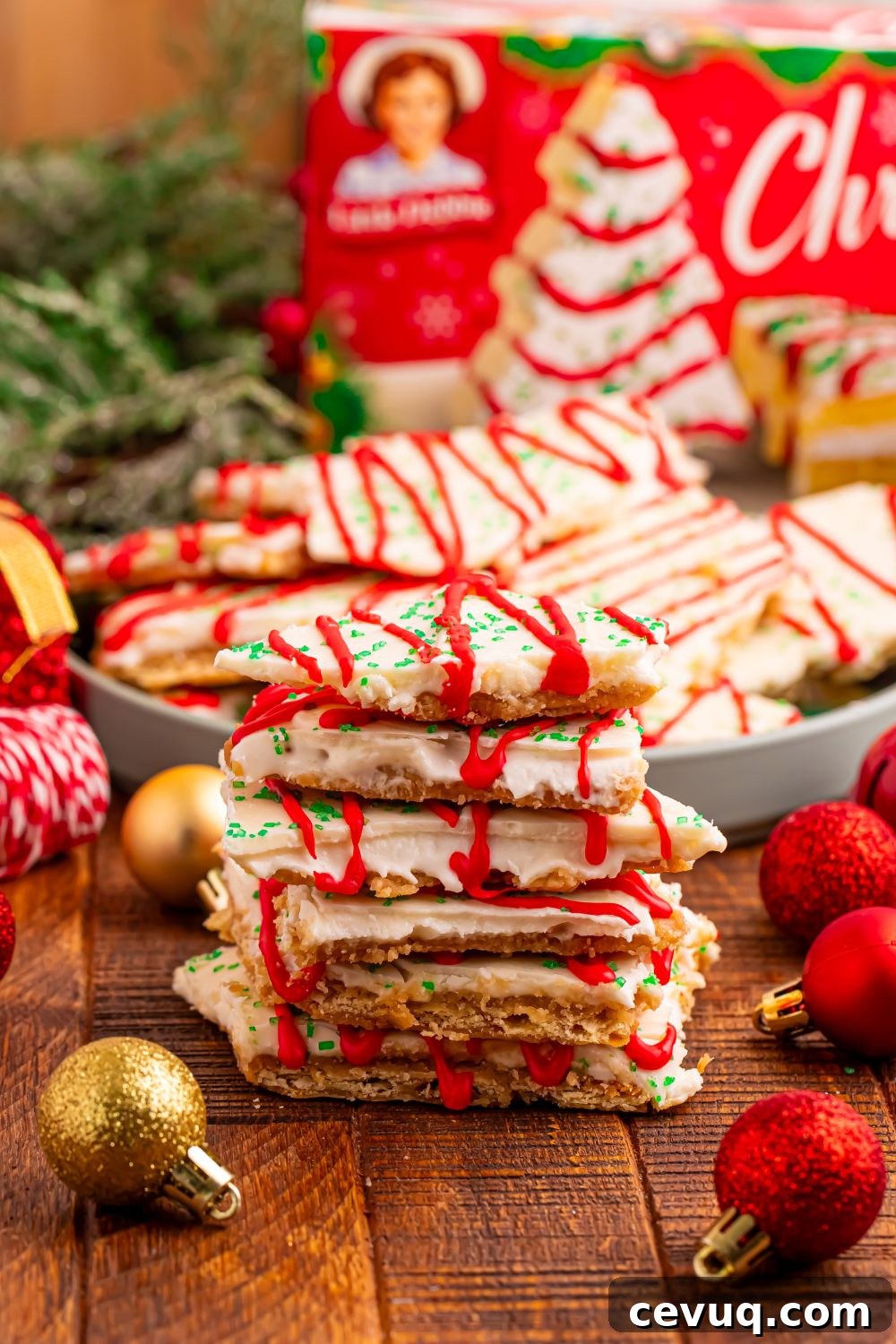 Christmas Tree Crack stacked in front with a bowl of more crack behind it and holiday decorations around the plate