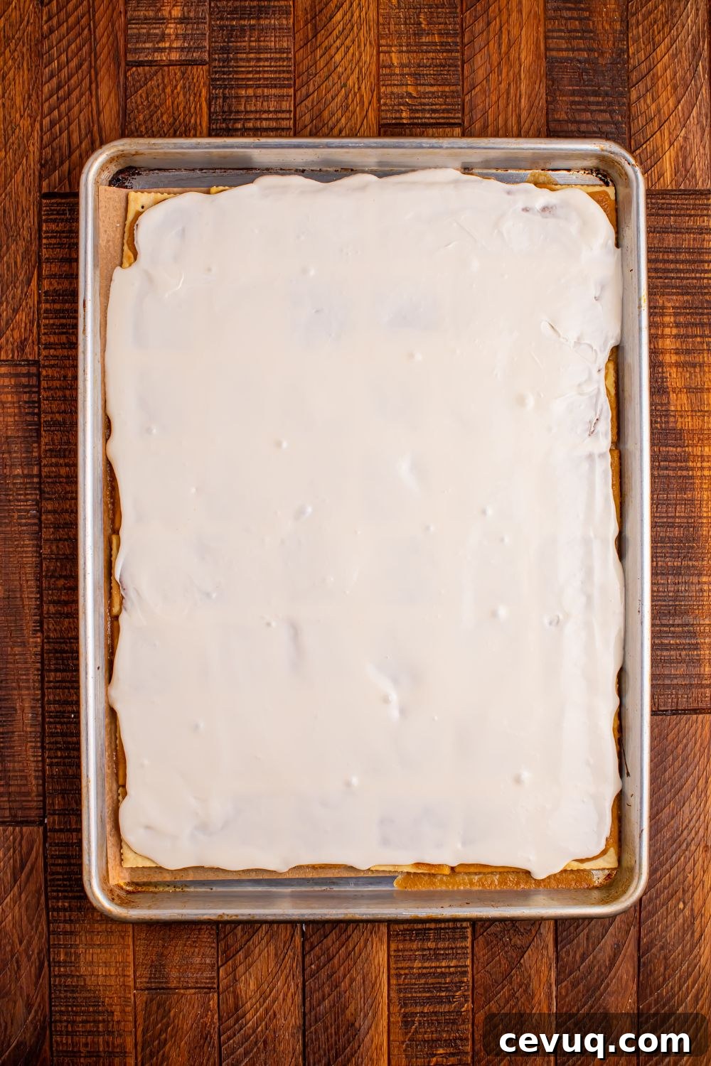 Christmas Tree Crack in a pan with the cream cheese frosting spread on top