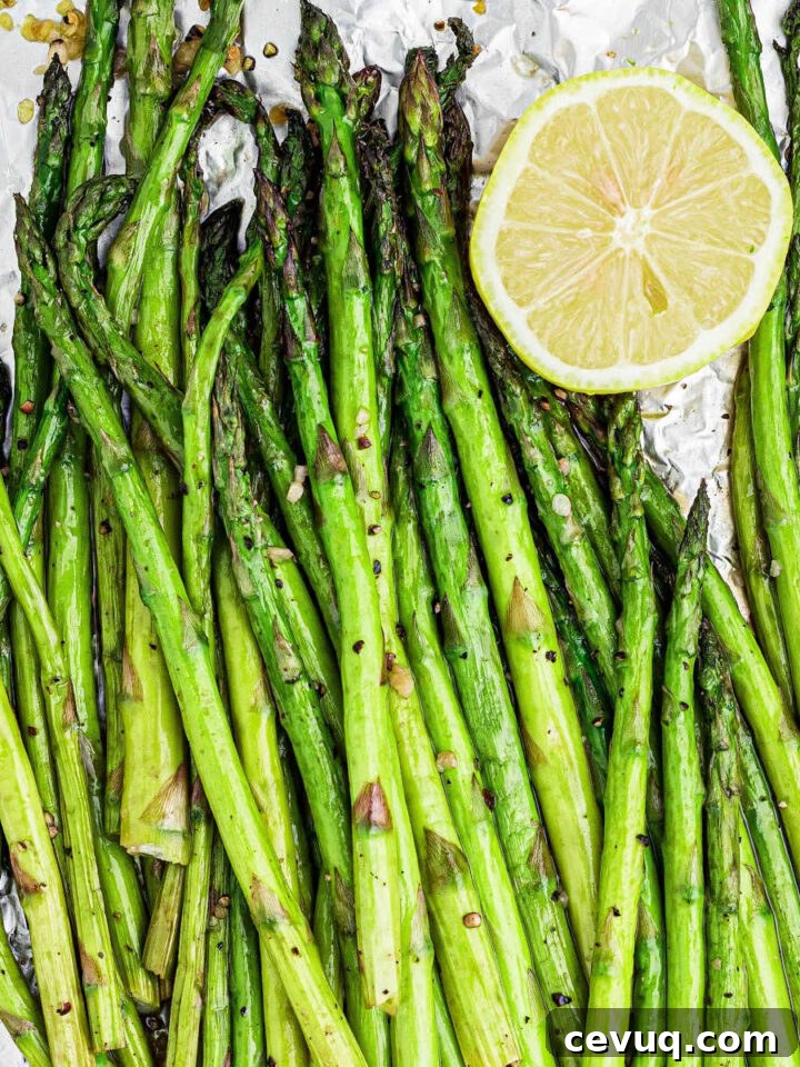 overhead close up of some smoked asparagus with some lemon on the side cropped square.